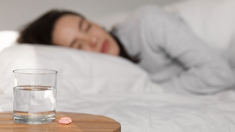 Frau im Bett nach Einnahme von Schlaftabletten