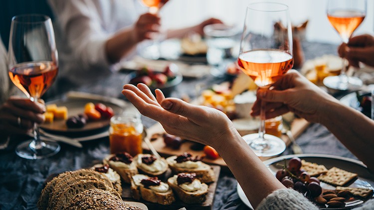 Freunde beim Essen mit Roséwein